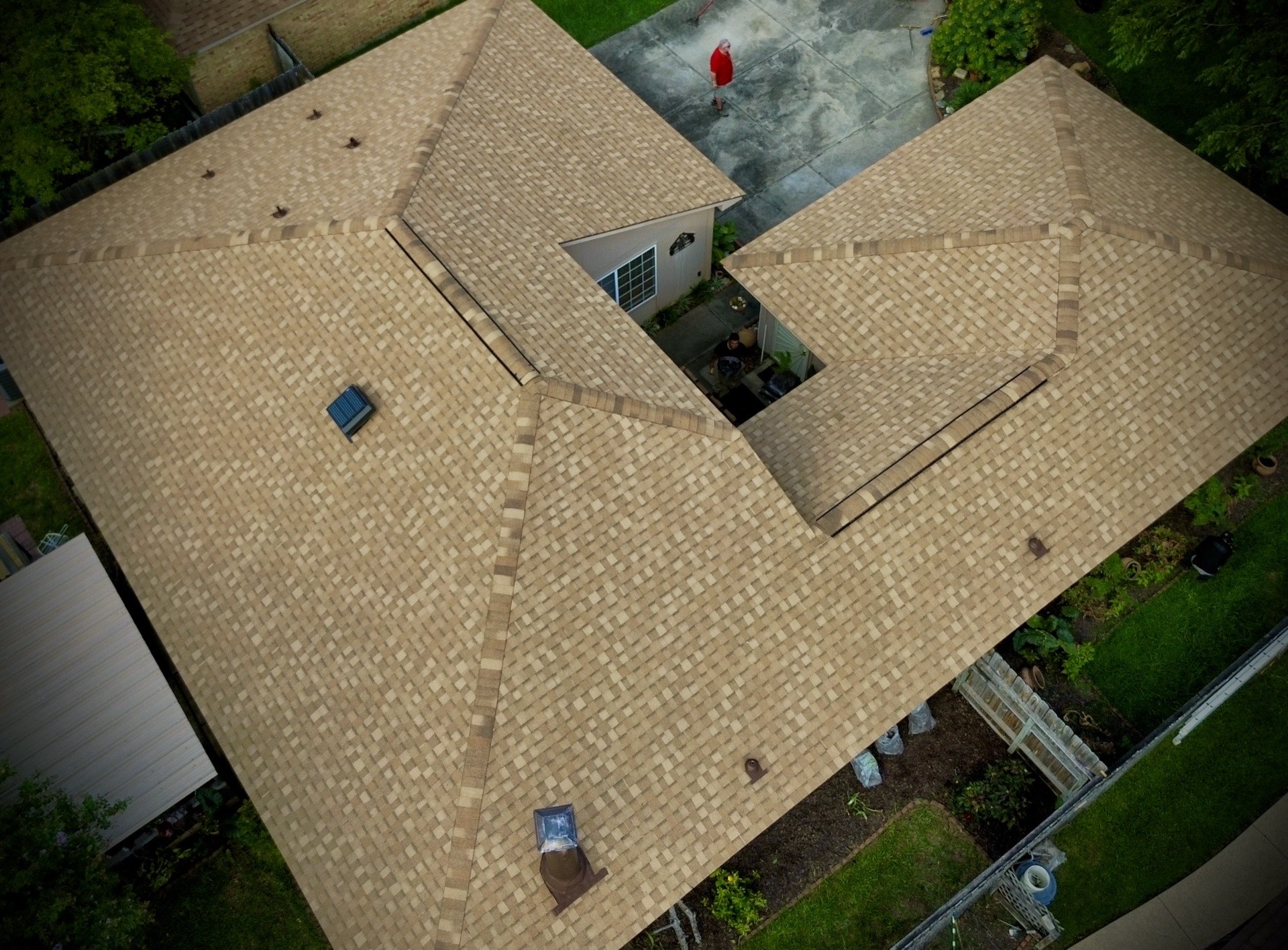 Roof inspection and maintenance on a tan shingle roof by Recon Roofing